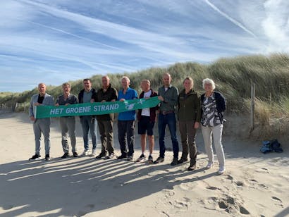 Wethouder Ferwerda (geheel links) nam de groene Strand Wimpel in ontvangst samen met de strandvrijwilligers en medewerkers van Het Zuid-Hollands Landschap.
